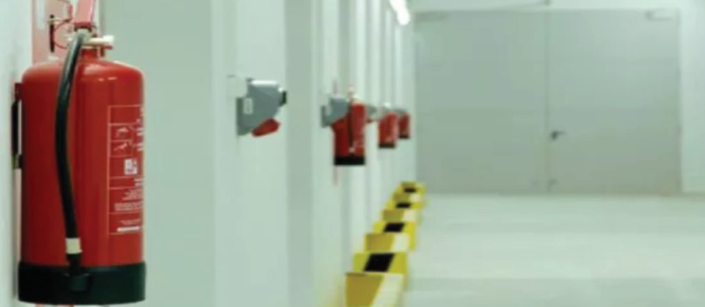 Wall-mounted fire extinguishers in a corridor